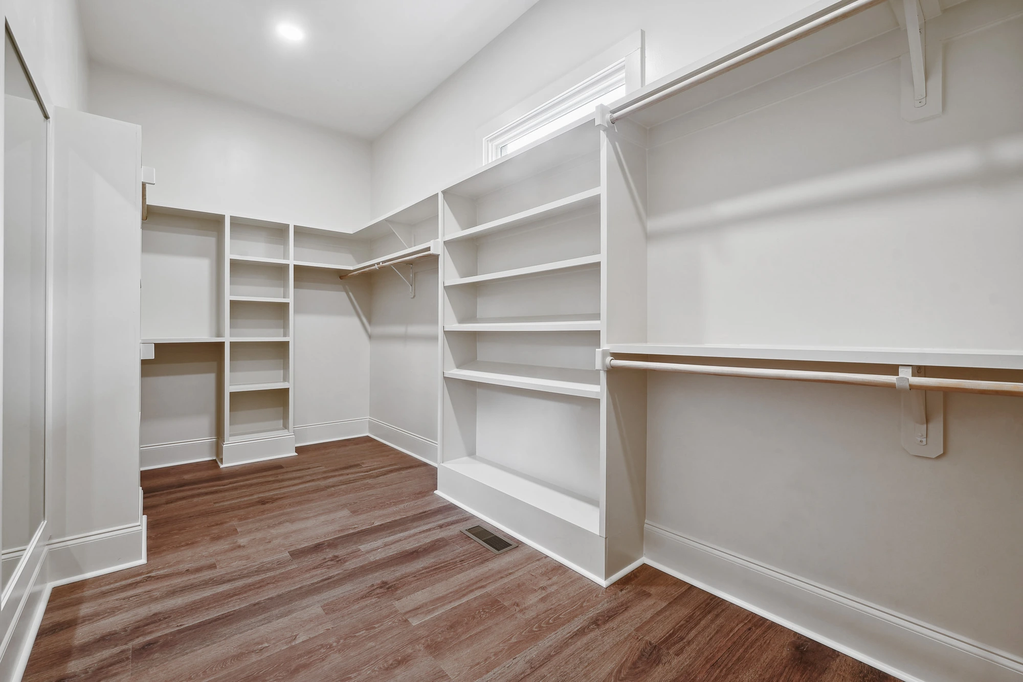 Custom walk-in closet with built-in shelving in Holly Springs home