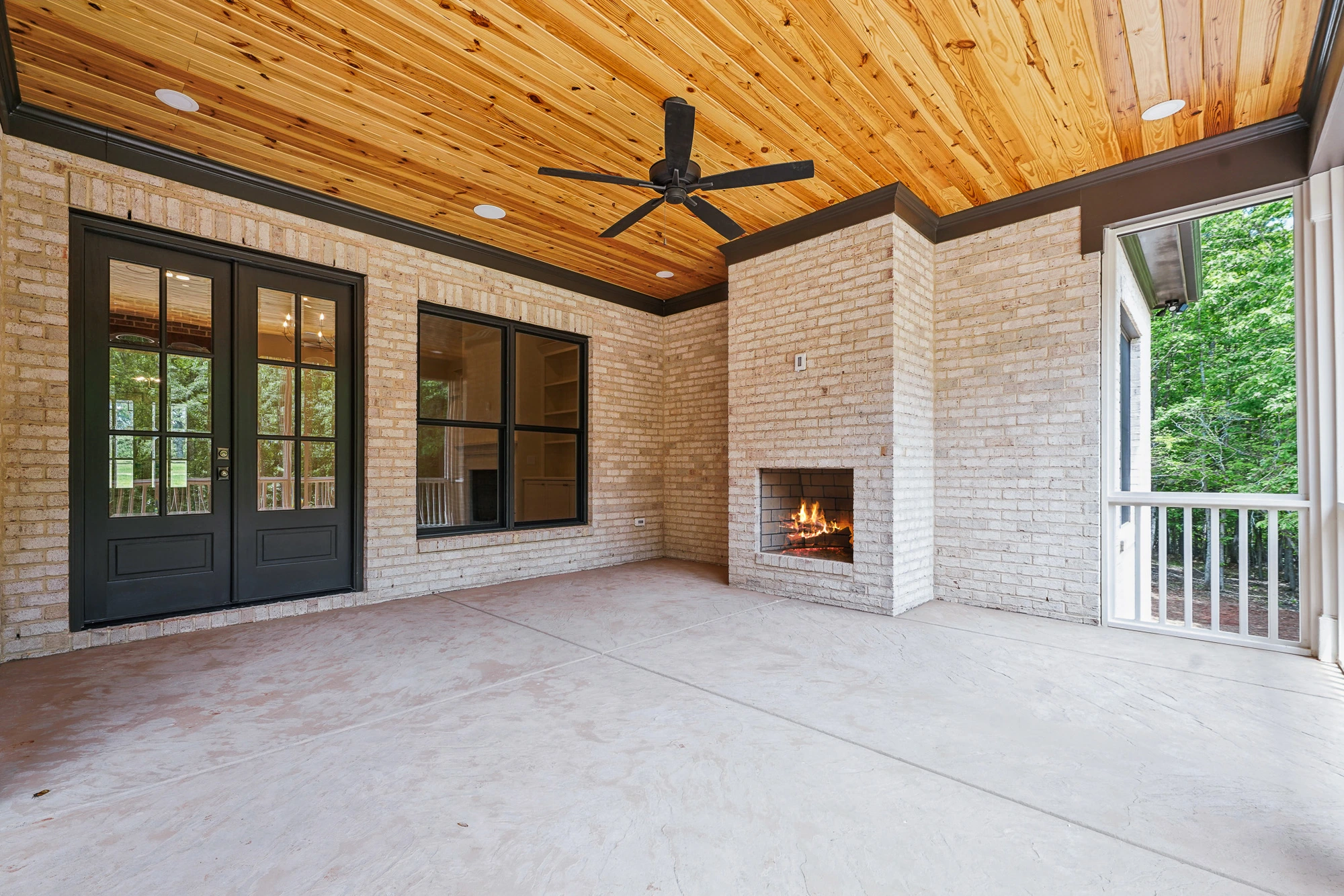 Screened porch with brick fireplace and wood ceiling in Holly Springs home